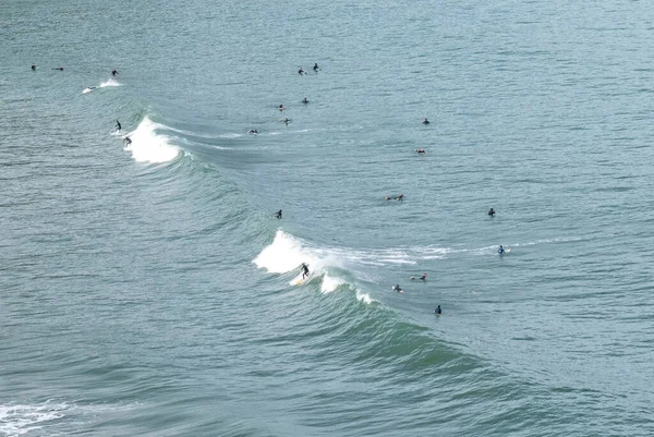 コブレセスのプラヤデルアナビーチでカンタブリアの海岸で大きな波をサーフィン多くのサーファー — ストック写真