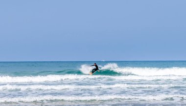 Rodiles, Asturias / İspanya - 6 Kasım 2020: İspanya 'nın kuzeyinde Asturias' ta muhteşem dalgalarda sörf yapan dalgıç kıyafetli adam