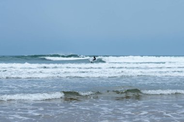 Rodiles, Asturias / İspanya - 6 Kasım 2020: İspanya 'nın kuzeyinde Asturias' ta muhteşem dalgalarda sörf yapan dalgıç kıyafetli adam