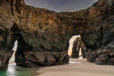 Kuzey İspanya 'daki Galiçya' daki Playa de las Catedrales Plajı 'nda güzel bir gün doğumu.