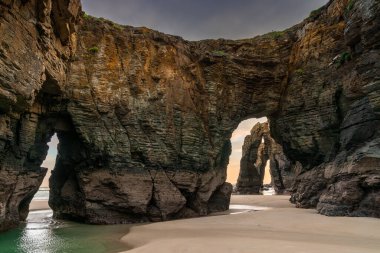 beautful sunrise at the Playa de las Catedrales Beach in Galicia in northern Spain clipart