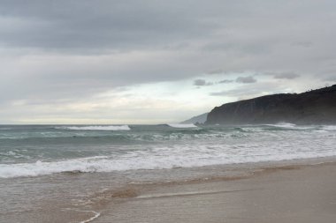 Boş ve büyük güzel altın kumsal Kötü hava gökyüzünün altında