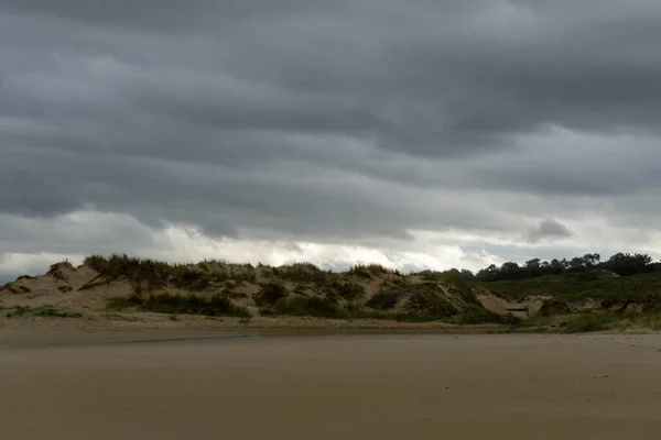 Bulutlu Bir Gökyüzünün Altında Kumulları Olan Boş Bir Sahil — Stok fotoğraf