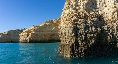 Atlantik kıyısında deniz mağaraları olan parlak mavi gökyüzünün altında güzel kayalar ve uçurumlar.