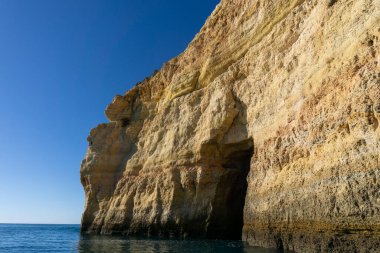 Atlantik kıyısında deniz mağaraları olan parlak mavi gökyüzünün altında güzel kayalar ve uçurumlar.