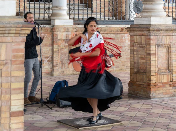 Seville, İspanya - 10 Ocak 2021: Sevilla Plaza de Espana 'da dans eden renkli elbiseli tutkulu flamenko dansçısı kadın