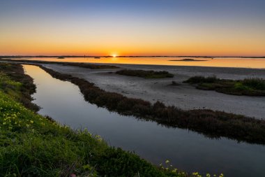 Sulak alanlar ve kanallar üzerinde renkli bir gökyüzü olan güzel bir gece doğumu.