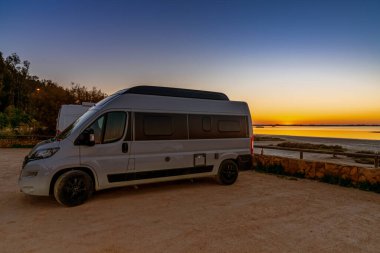 San Fernando, İspanya - 16 Ocak 2021: Bataklık ve kanalların üzerinde renkli bir gökyüzü ve ön planda bir karavan.