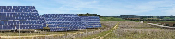 A panorama view of many large solar energy panels in the countryside of Andalusia