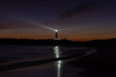 Cape Trafalgar deniz fenerinin gün batımından sonra renkli akşam gökyüzü manzarası