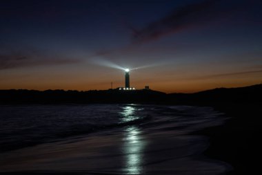Cape Trafalgar deniz fenerinin gün batımından sonra renkli akşam gökyüzü manzarası