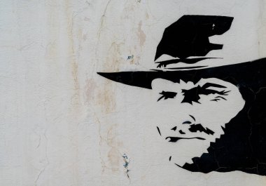 Tabernas, Spain - 6 February, 2021:  painted Clint Eastwood cowboy mural on a wall in the Oasys Western Theme Park in the Tabernas Desert in Andalusia clipart