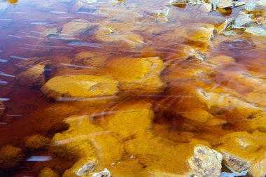 Rio Tinto madencilik bölgesinde demir cevheri ve bakır cevherleriyle turuncu kırmızı nehri kapatın.