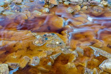 Rio Tinto madencilik bölgesinde demir cevheri ve bakır cevherleriyle turuncu kırmızı nehri kapatın.