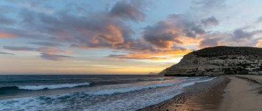 İspanya 'da Costa del Sol' da güzel bir okyanus batımı sahili ve arka planda kayalıkları olan.