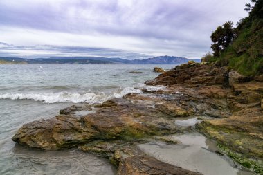 Galiçya 'nın batı kıyısında dalgaları olan kayalık bir sahil.