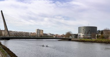 Pontevedra, Galiçya / İspanya - 2 Aralık 2020: Pontevedra Nehri 'nde Dos Tirantes Köprüsü ve Pazo da Cultura binasının arkasındaki kayakçılar