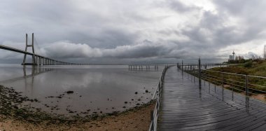 Lizbon 'daki Vasco da Gama Köprüsü' nün bulutlu gökyüzü altında manzarası