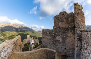 El Castell de Guadalest 'teki kayalıkların tepesindeki eski kale harabeleri ve kilise manzarası