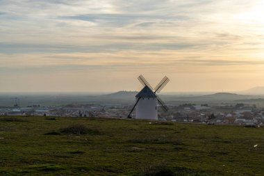 Campo de Criptana 'da sıcak bir akşam ışığında beyazlatılmış bir İspanyol yel değirmeni.