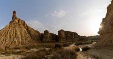 A panorama view of the Castildetierra cliff and desert grasslands in the Bardenas Reales desert in northern Spain with a sun star clipart