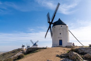 La Mancha 'da, Consuegra' nın yukarısındaki bir tepenin üzerinde, beyazlatılmış İspanyol yel değirmenlerinin manzarası.