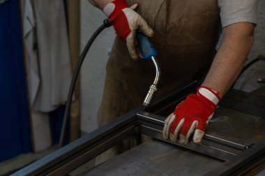 Bahçe verandası için metal çerçeve üreten bir metal işçisi.