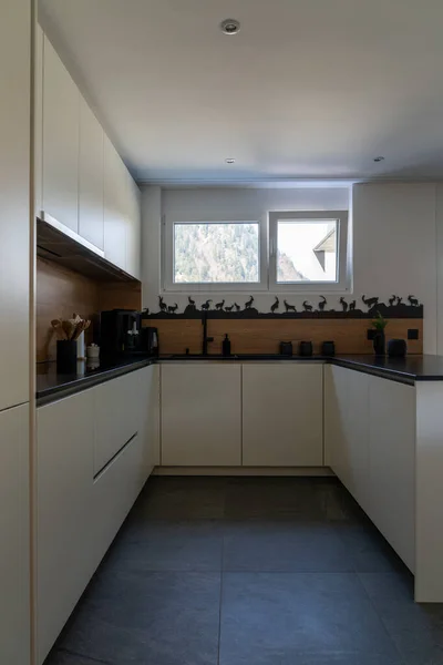 一个有白色橱柜和黑色瓷砖的现代典雅厨房的内部景观 — 图库照片