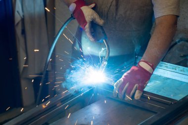 Bahçe verandası için metal çerçeve üreten bir metal işçisi.