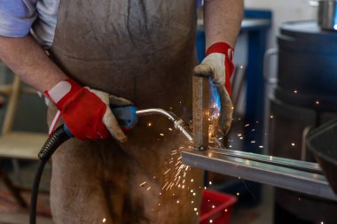 Bahçe verandası için metal çerçeve üreten bir metal işçisi.