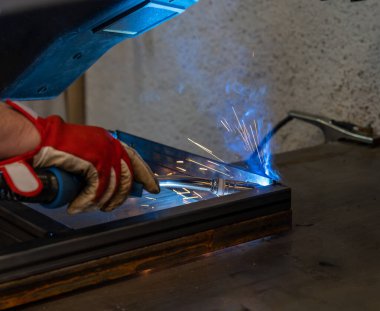 Bahçe verandası için metal çerçeve üreten bir metal işçisi.