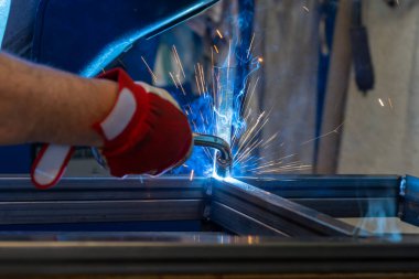 Bahçe verandası için metal çerçeve üreten bir metal işçisi.