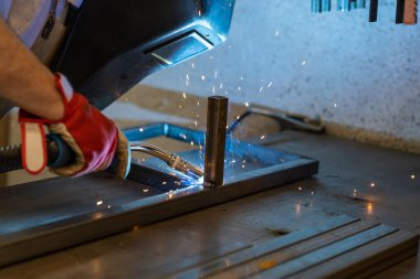 Sahtecilik ve metal atölyesinde çelik çerçeveler yapan bir adamın ayrıntıları.