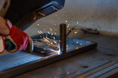 Bahçe verandası için metal çerçeve üreten bir metal işçisi.