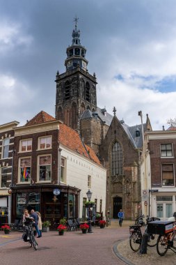 Gouda, Hollanda - 15 Mayıs 2021: Bisiklet süren insanlarla birlikte tarihi şehir merkezi Gouda manzarası