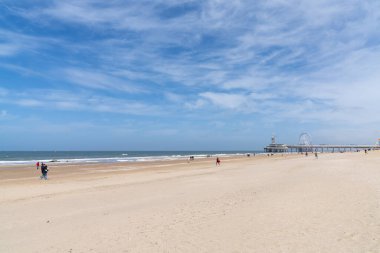 Scheveningen, Hollanda - 16 Mayıs 2021: İnsanlar Lahey yakınlarındaki Hollanda sahil beldesi Scheveningen 'de güneşli bir günün tadını çıkarıyorlar.