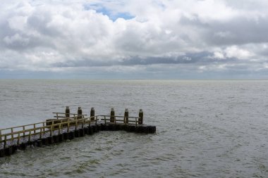 Kuzey Hollanda 'daki tipik Wadden Denizi manzarası Den Oever yakınlarında rüzgarlı bir okyanus ve anlamlı bulutlu bir gökyüzü