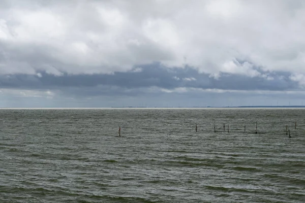 Kuzey Hollanda 'daki tipik Wadden Denizi manzarası Den Oever yakınlarında rüzgarlı bir okyanus ve anlamlı bulutlu bir gökyüzü