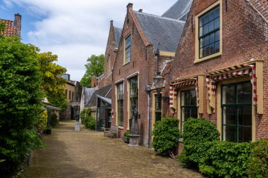 Haarlem, Hollanda - 21 Mayıs 2021: Haarlem 'in tarihi şehir merkezinde kırmızı tuğlalı binaları olan pitoresk mahalle caddesi