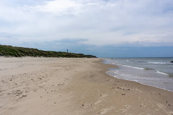 Egy Gyönyörű Fehér Homokos Strand Világítótoronnyal Háttérben Magasan Füves Homokdűnéken — Stock Fotó