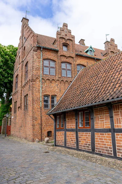 stock image beautiful historic half-timber houses and brick buldings line a cobblestone street in Ribe