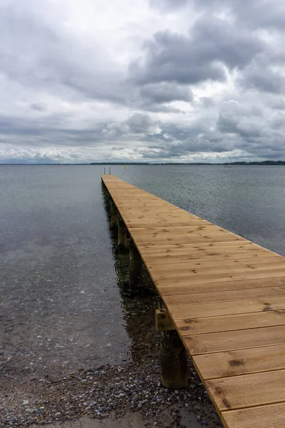 看到一个长长的木制码头通向清澈的海水 — 图库照片