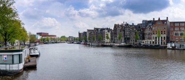 Amsterdam, Hollanda - 19 Mayıs 2021: Amstel Kanalı 'nın kenarlarında birçok tarihi bina bulunan Amsterdam manzarası