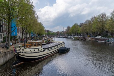 Amsterdam, Hollanda - 19 Mayıs 2021: Amstel Kanalı 'nın kenarlarında birçok tarihi bina bulunan Amsterdam manzarası