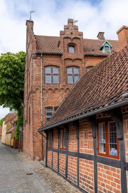 Güzel tarihi yarı ahşap evler ve tuğla ampuller Ribe 'de bir kaldırım taşı caddesinde.