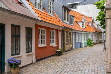 Aalborg, Danimarka - 7 Haziran 2021 Aalborg 'un tarihi şehir merkezinde bir kaldırım taşı caddesi ve renkli küçük evler