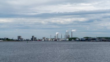 Aalborg, Danimarka - 7 Haziran 2021: Aalborg 'daki Limfjord sesi ve fabrika bacaları ile endüstriyel dikkat dağıtıcı görüntü