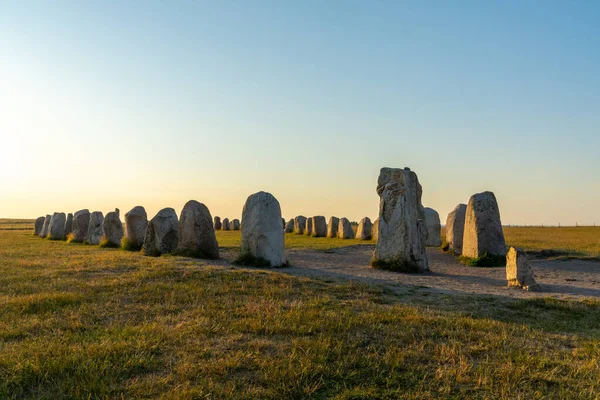 Landscape view of the prehistoric Ales Stenar ship setting on the southern coast of Sweden at sunset