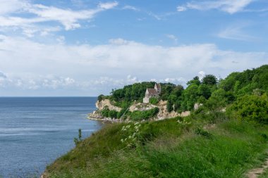Stevns Klint 'in beyaz kireçtaşı kayalıklarının tepesindeki Hojerup' taki kilisenin manzarası