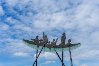 Nysted, Danimarka - 11 Haziran 2021: Nysted limanında beyaz bulutlu mavi gökyüzünün altında başarılı kürekçilerin heykeli